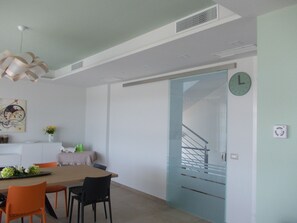 A dining area with a table, chairs, and a clock on the wall.