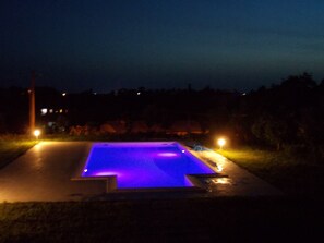 A swimming pool with a blue-lit edge at night.