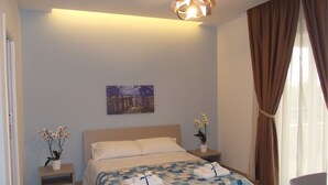 A bedroom with a bed, nightstands, a painting, and a potted plant. - Villa Lauro Luxury B&B (Castellabate)