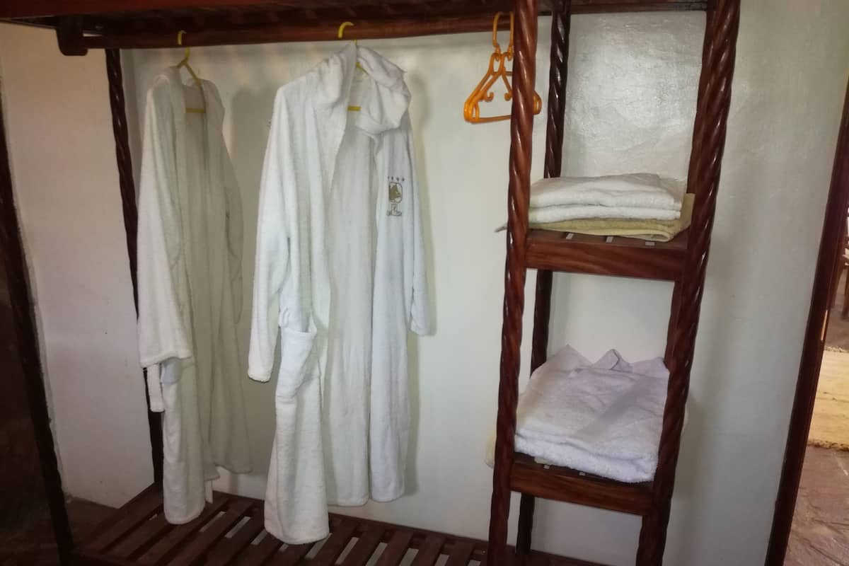 Una cama litera de madera con un estante inferior que sostiene una toalla blanca doblada.