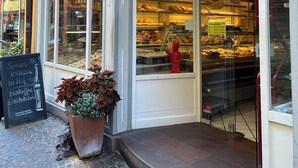 En café med en glaskasse fyldt med bagværk og en rød bjørnedekoration.