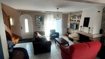 Télévision, cheminée, table de tennis de table, livres