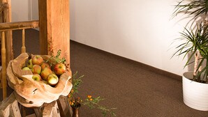 A wooden chair with a basket containing apples and a small plant. - Hotel Wagner (Bad Wimpfen)