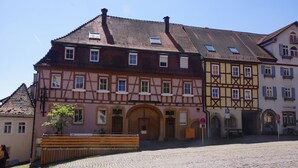 A traditional half-timbered building with a cobblestone street and a bench in front. - Hotel Wagner (Bad Wimpfen)