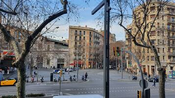 Una intersección urbana con edificios, semáforos y árboles.