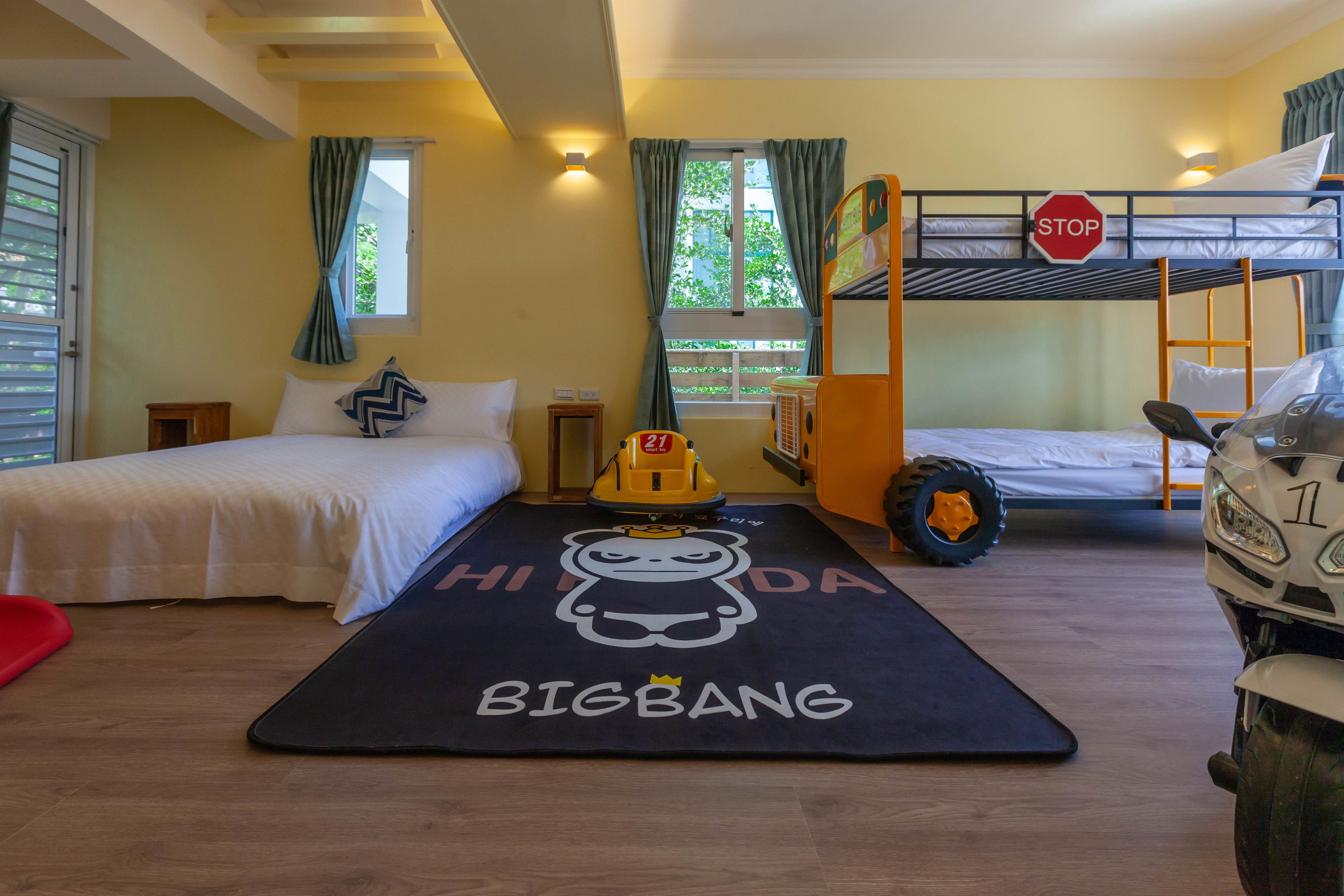 A bunk bed room with a stop sign, a toy car, and a motorcycle.
