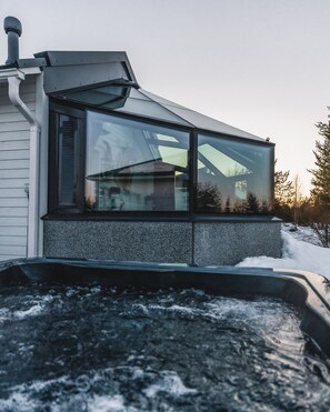 A modern building with large windows, a sloped roof, and a visible chimney. - Santa's Igloos Arctic Circle (Rovaniemi)
