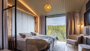 Un dormitorio moderno con una cama grande, una silla y un televisor.