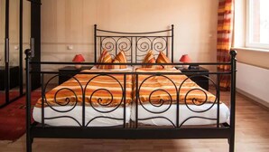 Un lit avec un cadre en métal, deux tables de chevet et une fenêtre avec des rideaux.