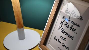 Une citation encadrée posée sur une table, à côté d’une lampe.