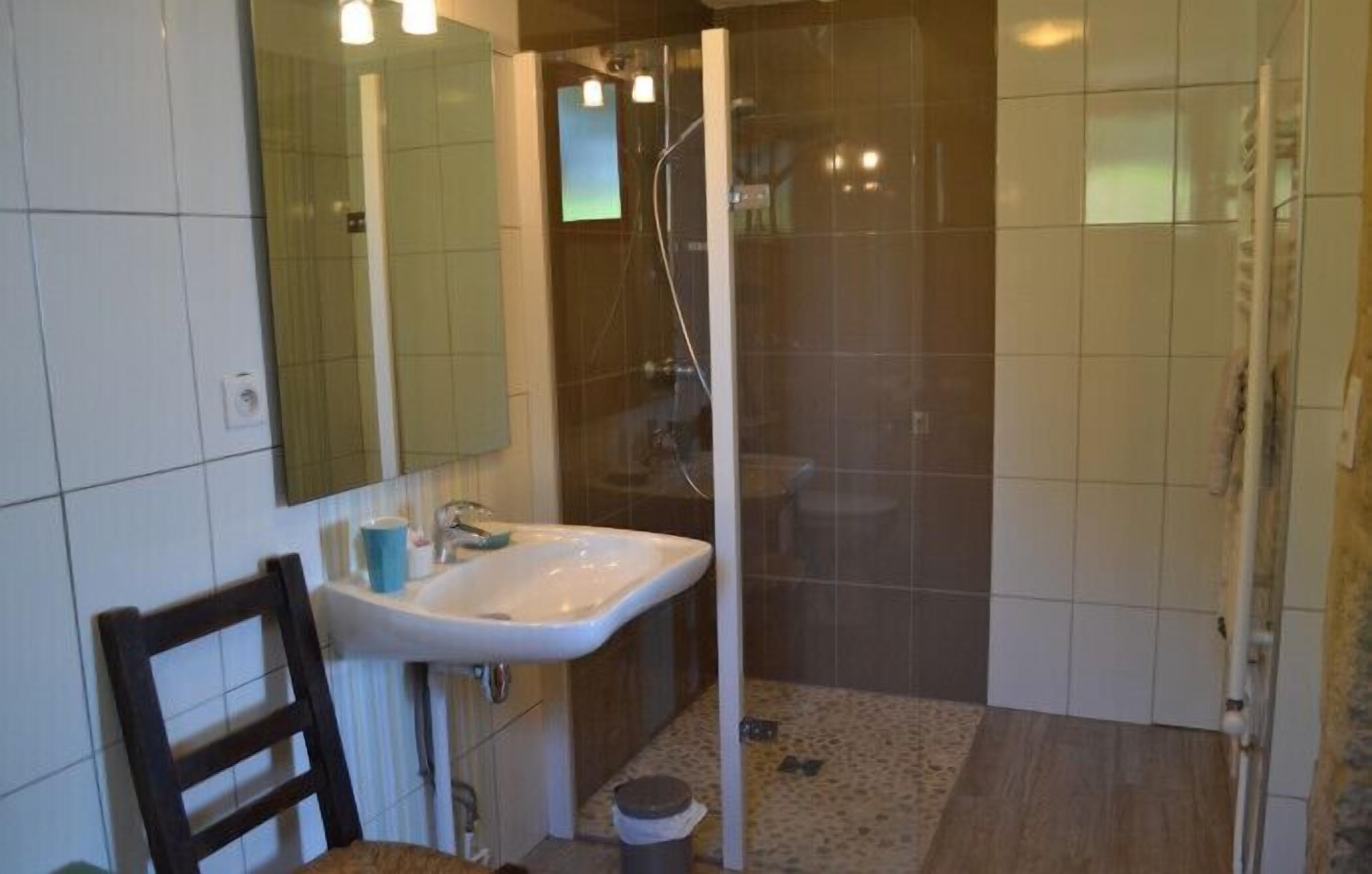 Un baño con lavabo, espejo y ducha.