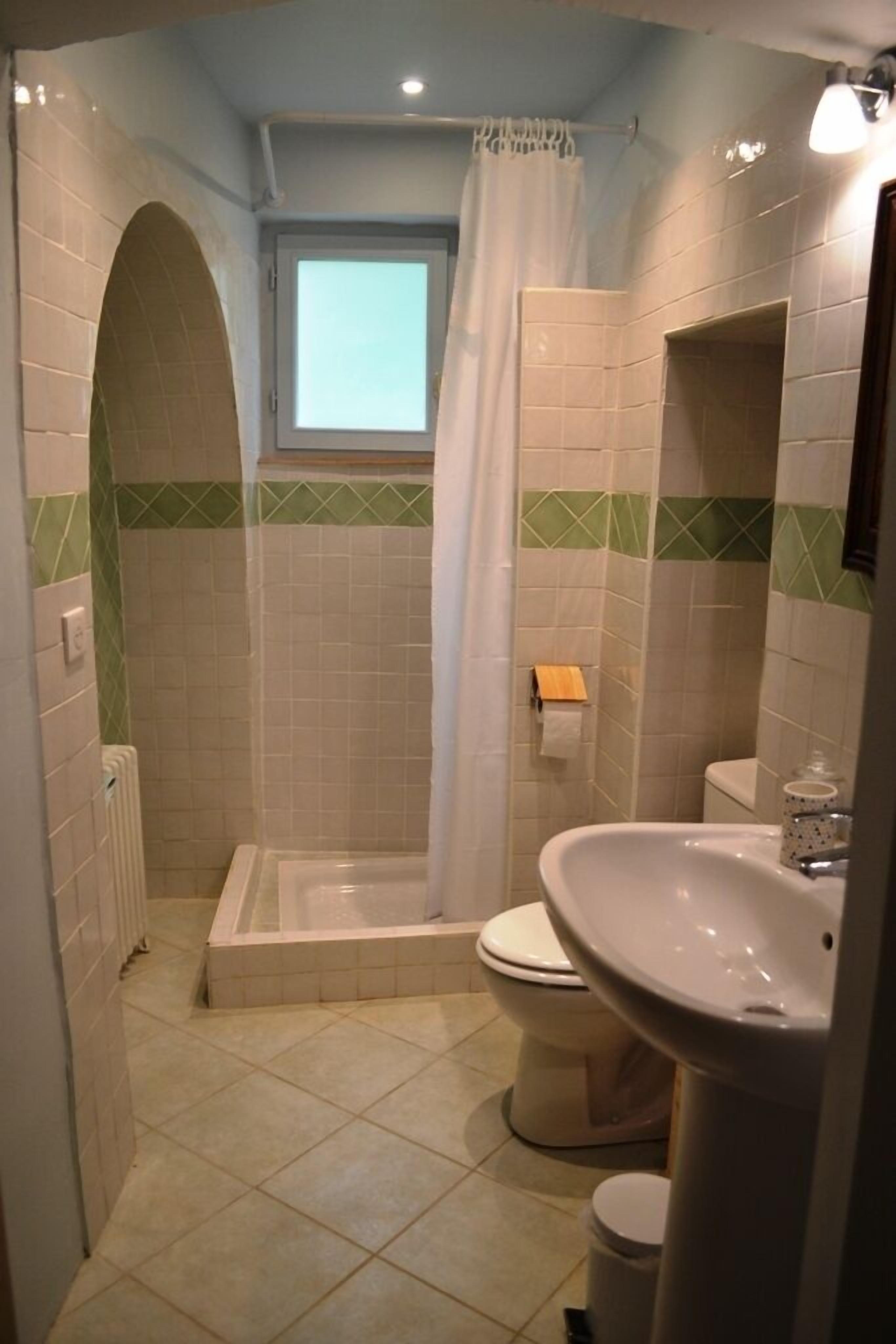 Un baño con ducha, inodoro y lavabo.