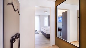 A modern hotel room with a large mirror, a bed, and a wooden floor. - Hotel Gasthof zum Ochsen (Arlesheim)