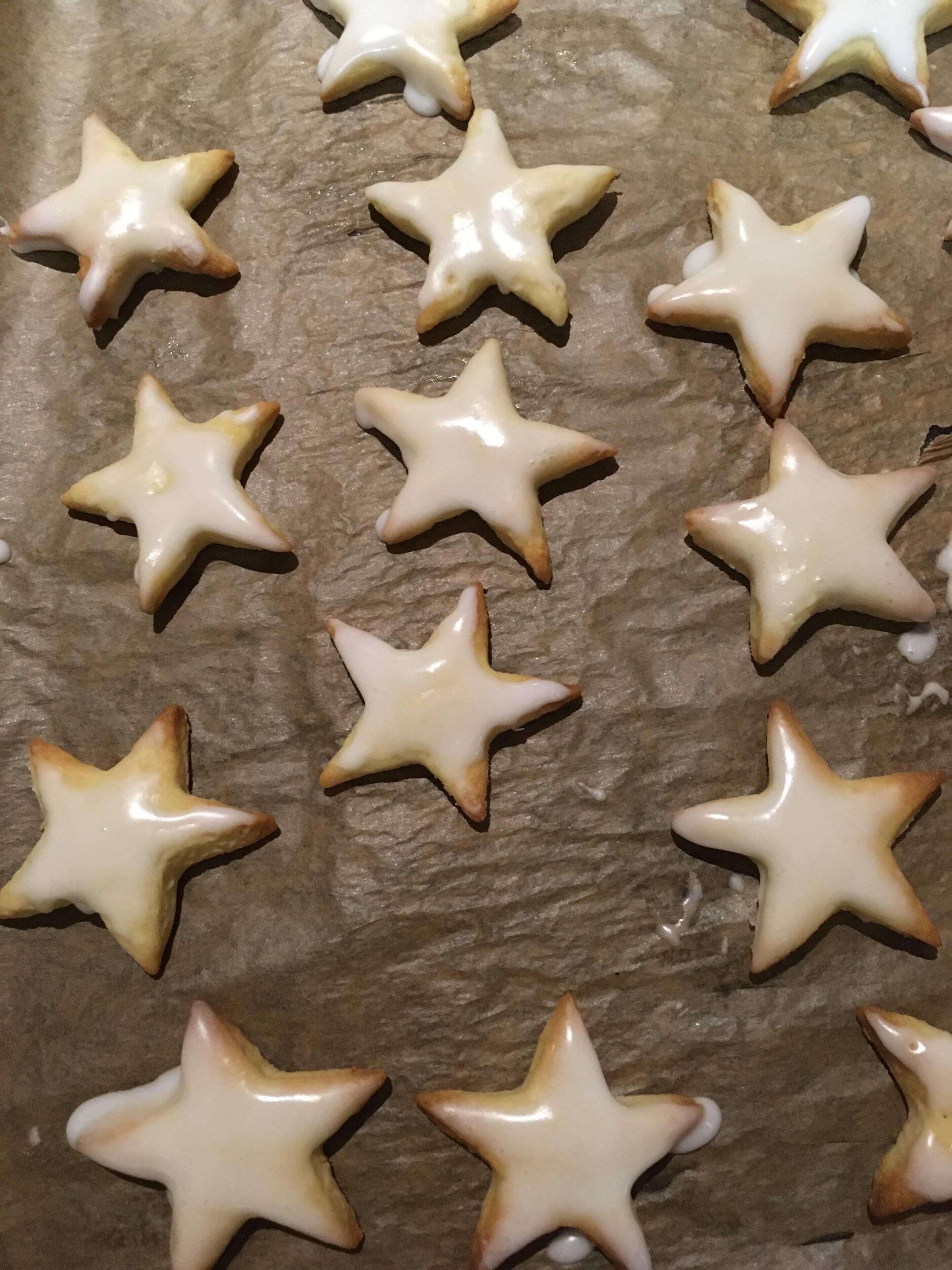 Un vassoio di biscotti a forma di stella con glassa.