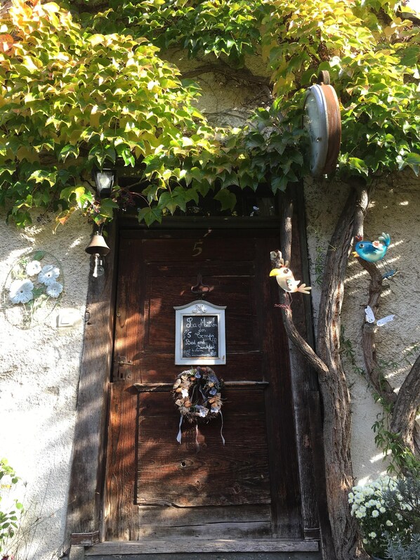 A rustic wooden door with a chalkboard sign, ivy, and decorative birds.