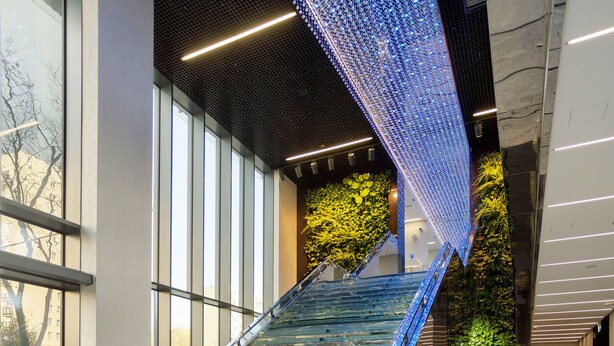 A modern interior with a glass staircase, a green wall, and a marble floor. - Vola Residence (Warsaw)