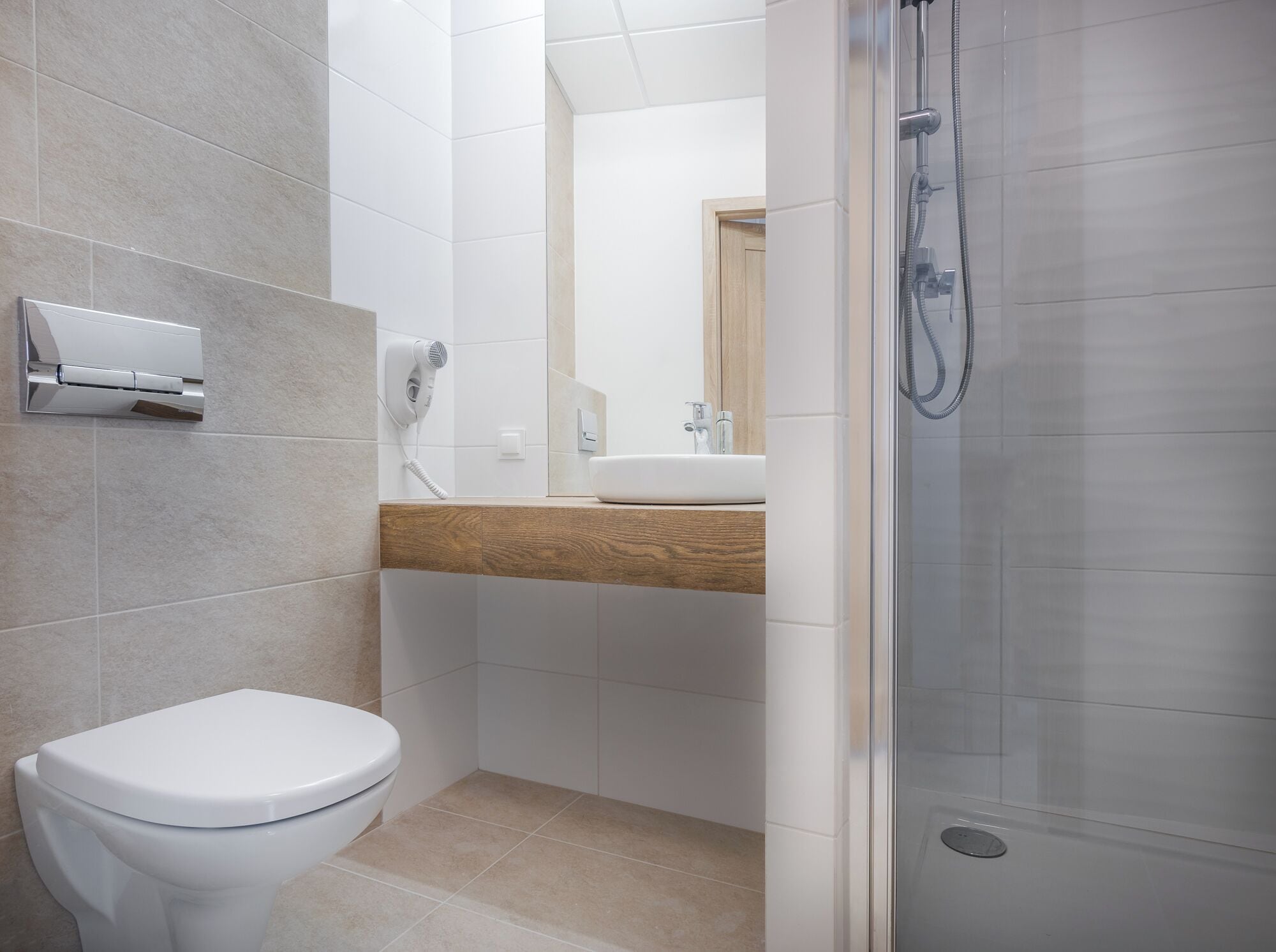 Een moderne badkamer met toilet, wastafel en douche.