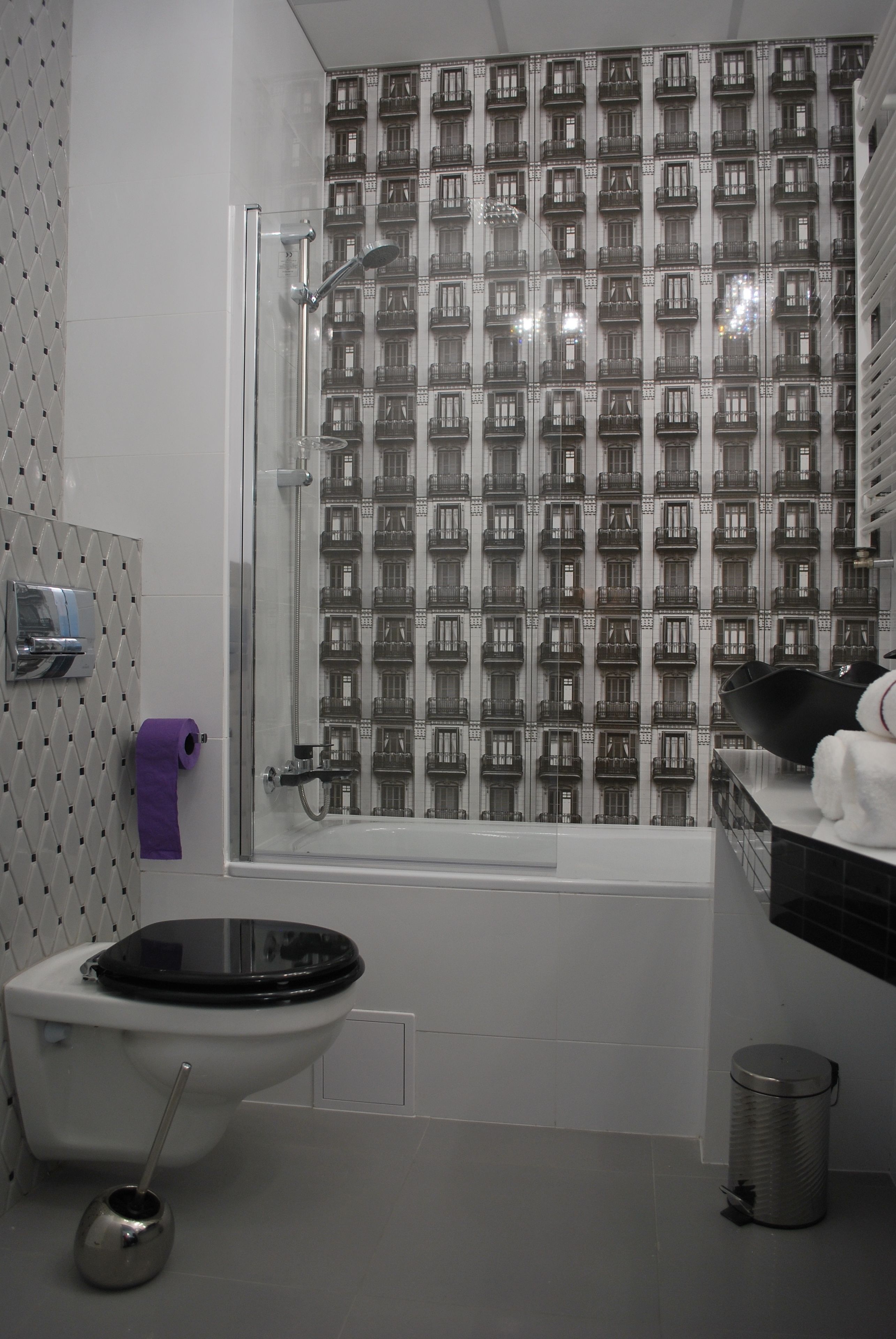 Et badeværelse med bruser, toilet og håndvask.