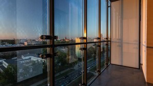 A high-rise building with large windows offering a view of a cityscape. - Vola Residence (Warsaw)