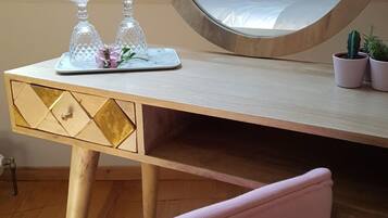 Un dormitorio con cama, una mesita de noche con cristalería decorativa y una planta en maceta.
