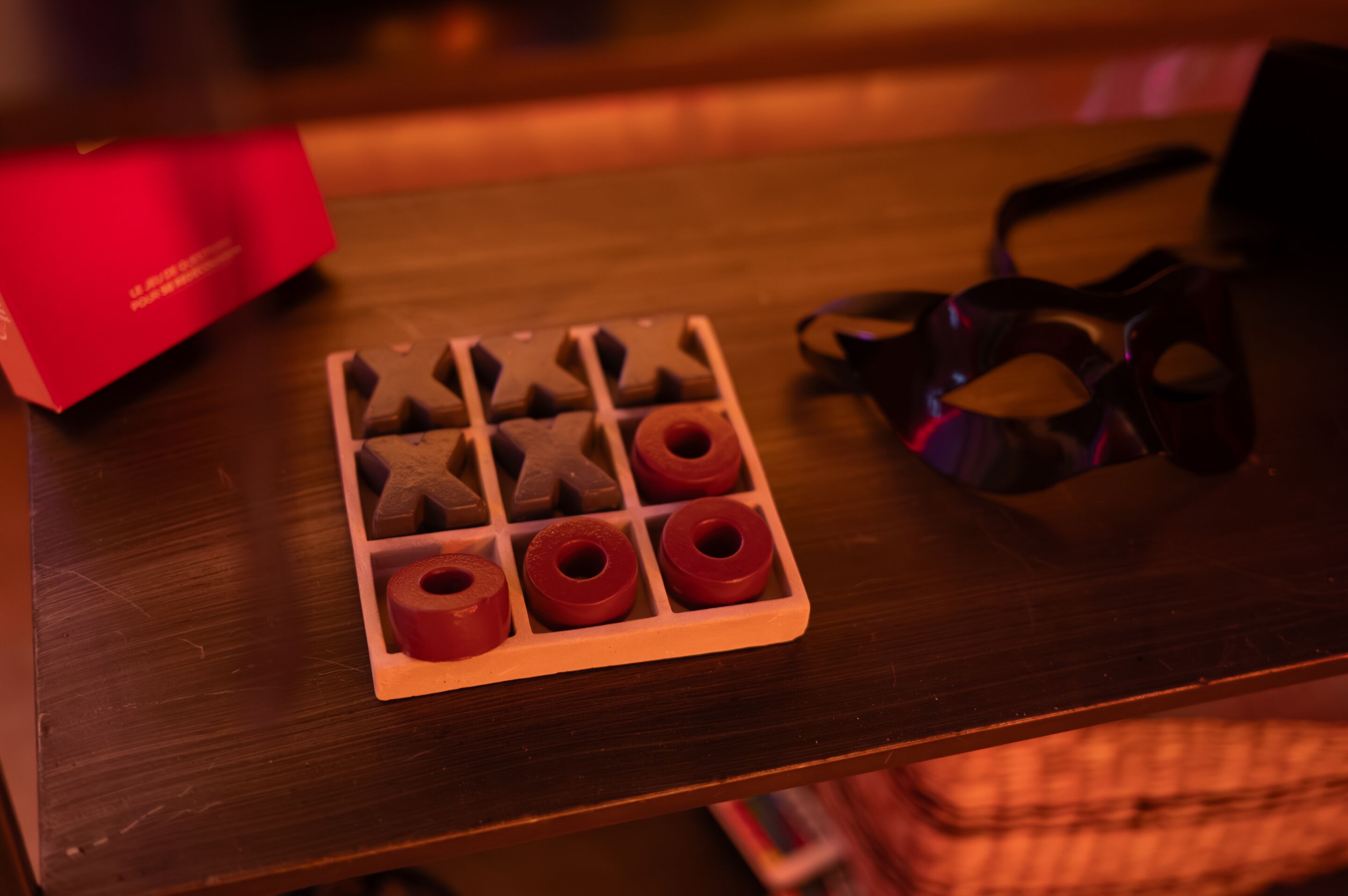 A tray with chocolate shapes and rings on a wooden table.