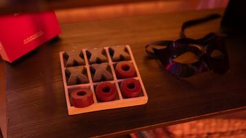 A tray with chocolate shapes and rings on a wooden table.