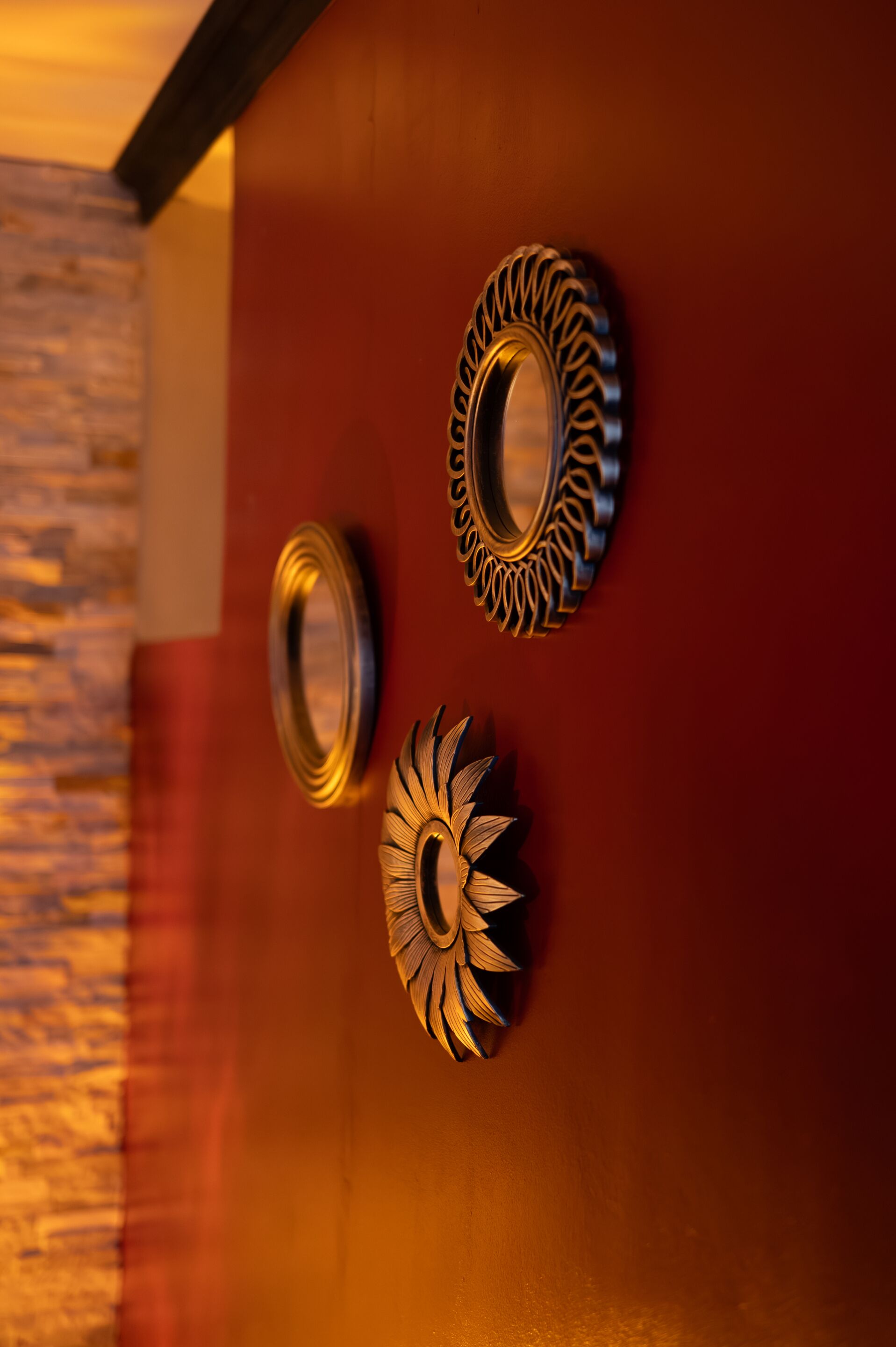 Tres espejos decorativos montados en la pared con diseños elaborados.