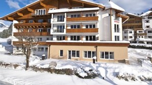 A multi-story hotel with a wooden facade and balconies, surrounded by snow-covered landscape. - Seiwald (Kirchdorf in Tirol)