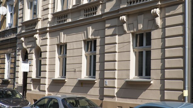 A multi-story building with classical architectural features, including arched windows and decorative moldings. - Fresh Apartments (Kraków)