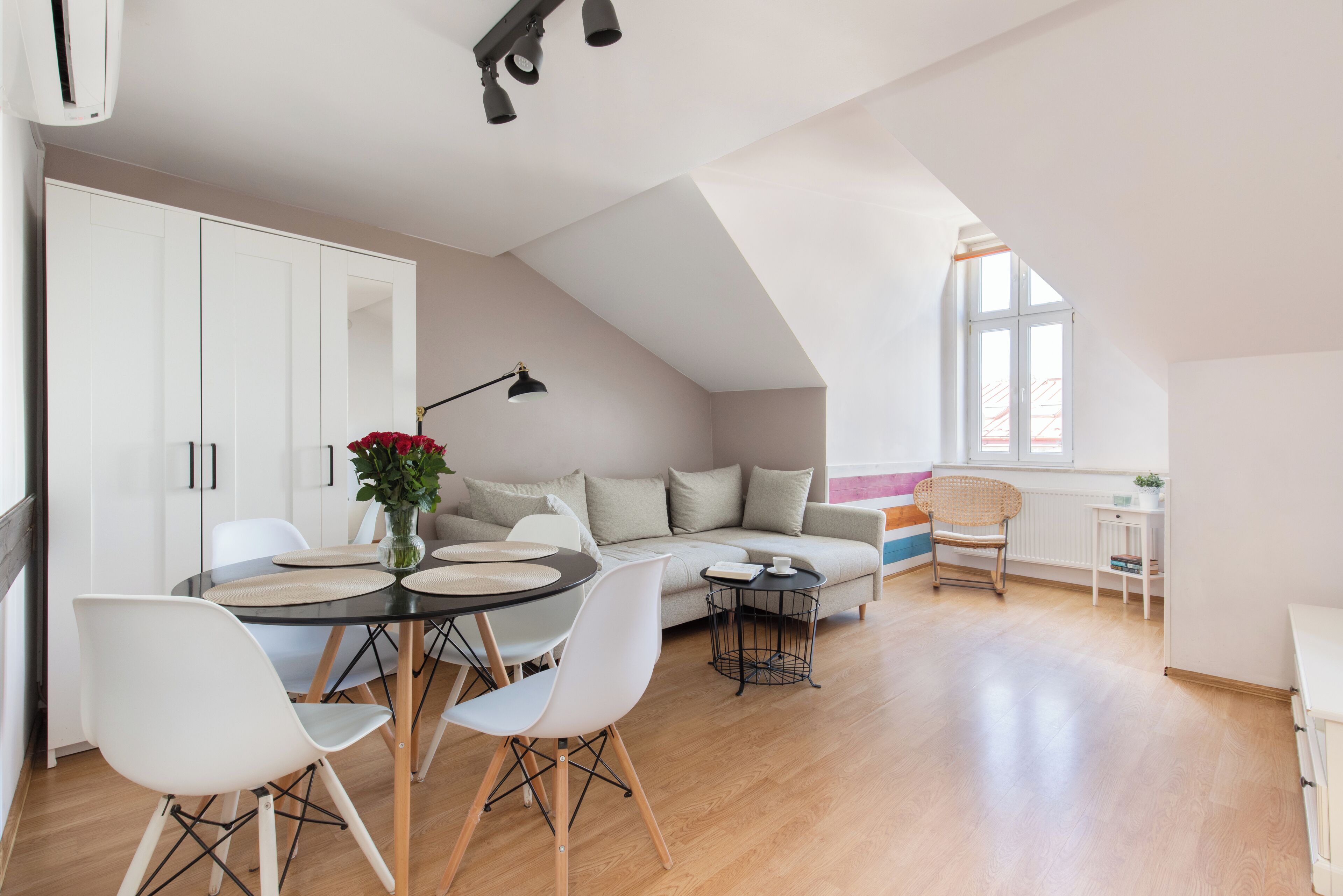Un appartement moderne de style « loft », comprenant un coin repas, un canapé et une petite table.