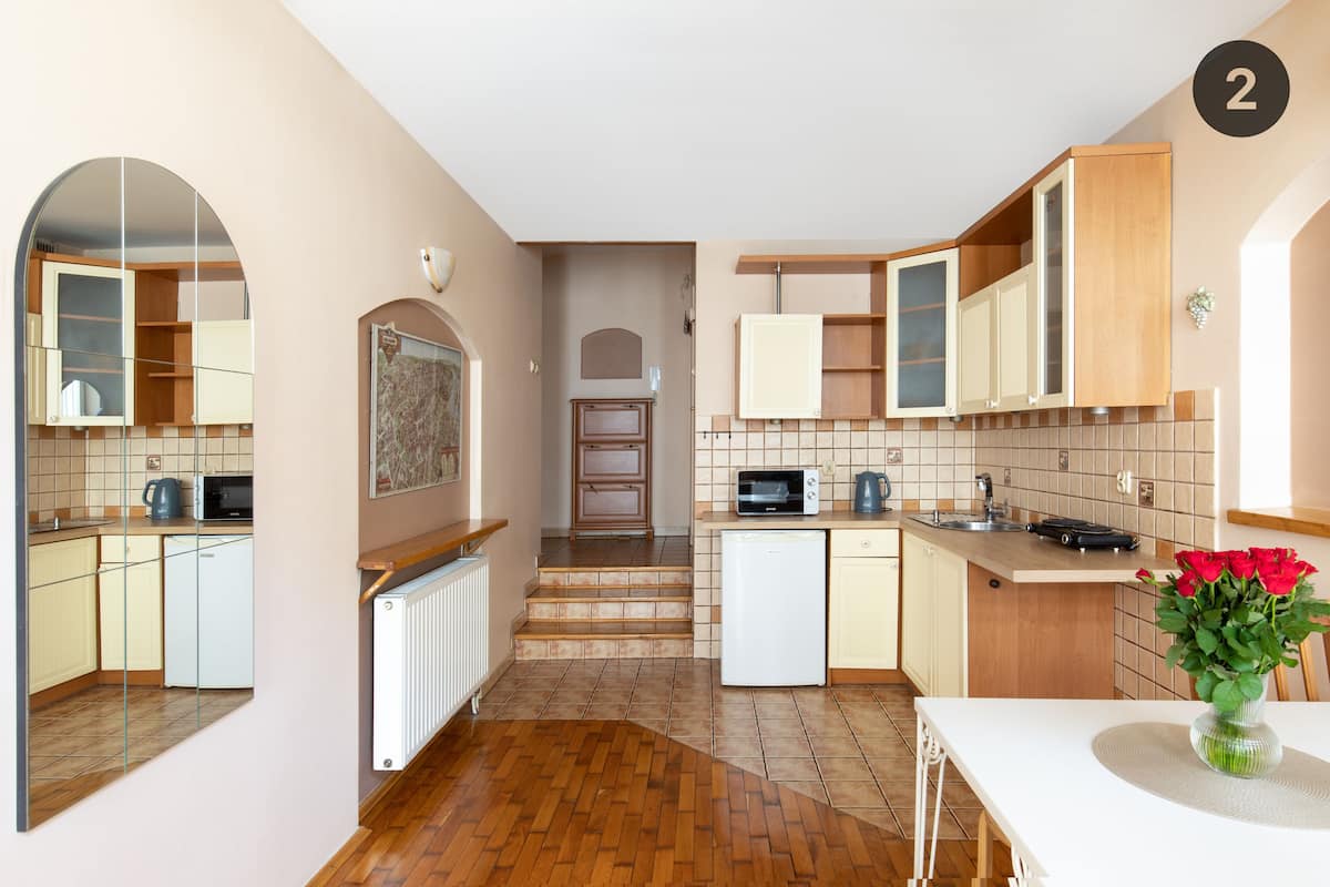 A modern kitchen with wooden cabinets, a microwave, and a small refrigerator.