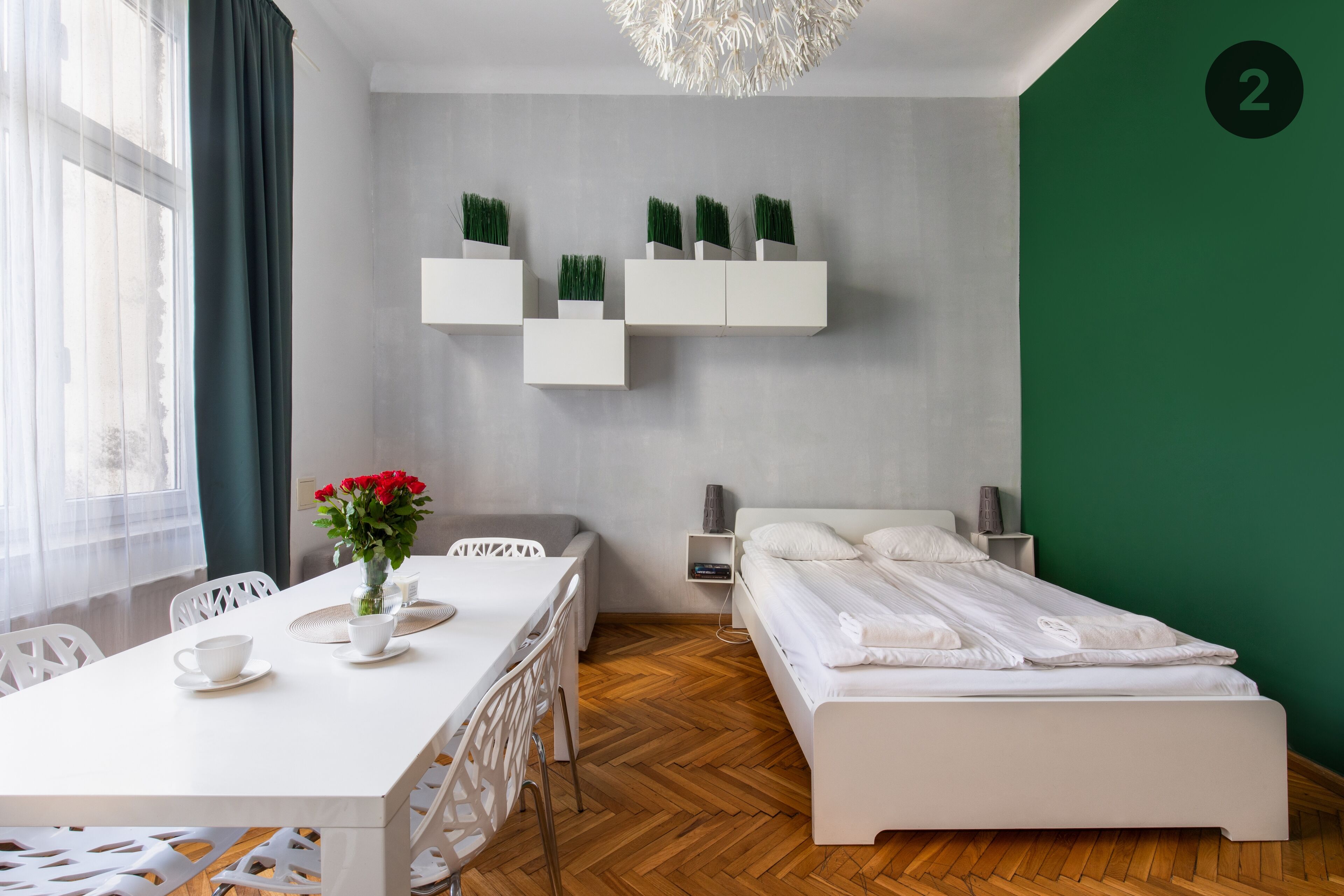 Un dormitorio moderno con cama, mesita de noche y escritorio con sillas.