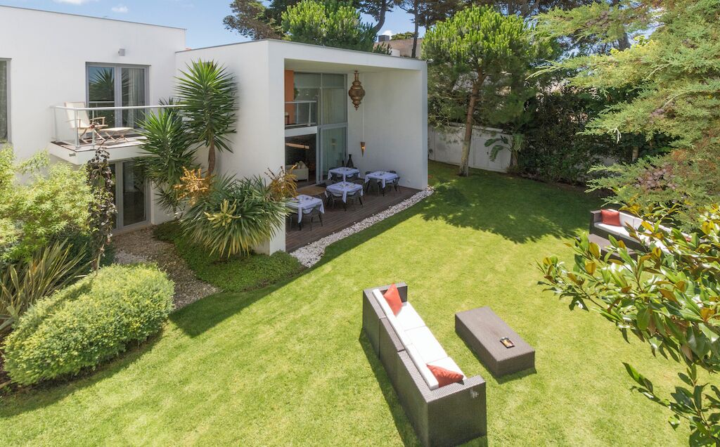 Una casa moderna con un patio que tiene un espacio de descanso y una pequeña mesa.