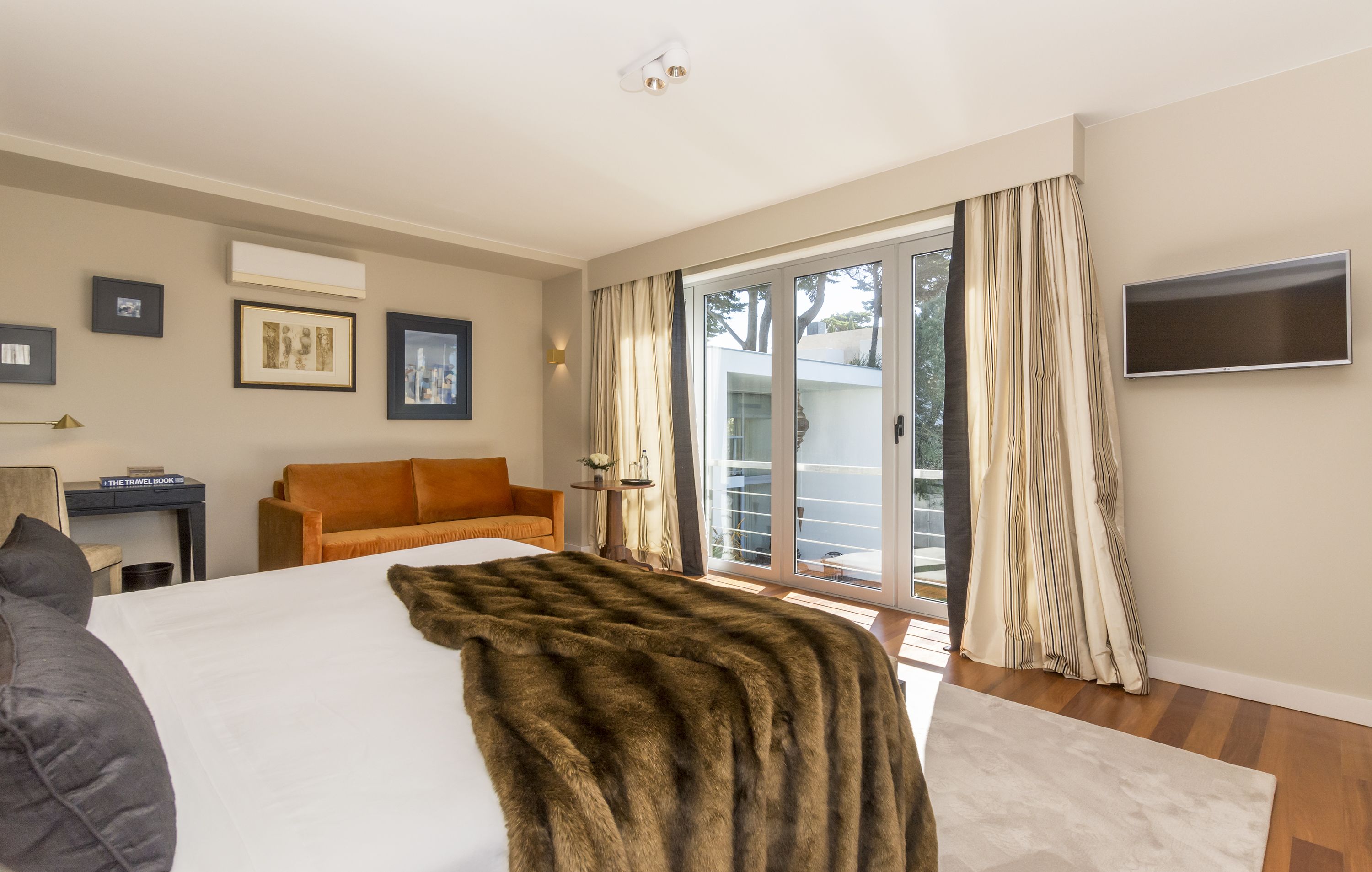 Une chambre d’hôtel avec un grand lit, un canapé, un bureau et une télévision.