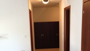 A hallway with a beige sofa, dark cabinets, and a ceiling light.