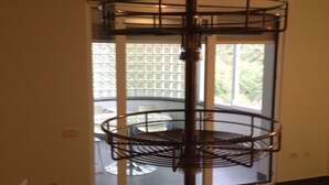 A multi-tiered metal rack in a room with a large window and a door.