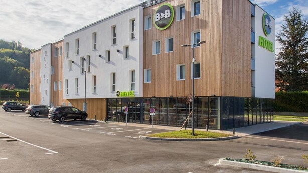 A modern B&B hotel with a wooden facade, multiple windows, and a clear sky. - B&B HOTEL ANNEMASSE Saint-Cergues (Saint-Cergues)