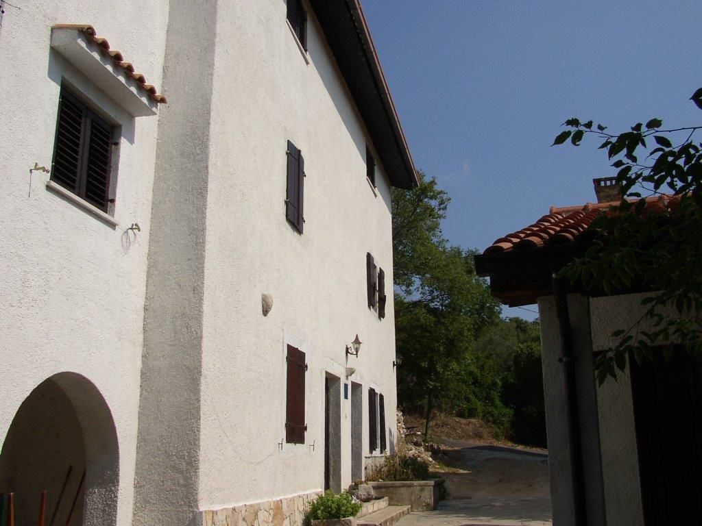 A white building with multiple windows and a tiled roof.