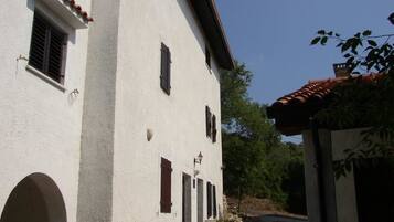 A white building with multiple windows and a tiled roof.
