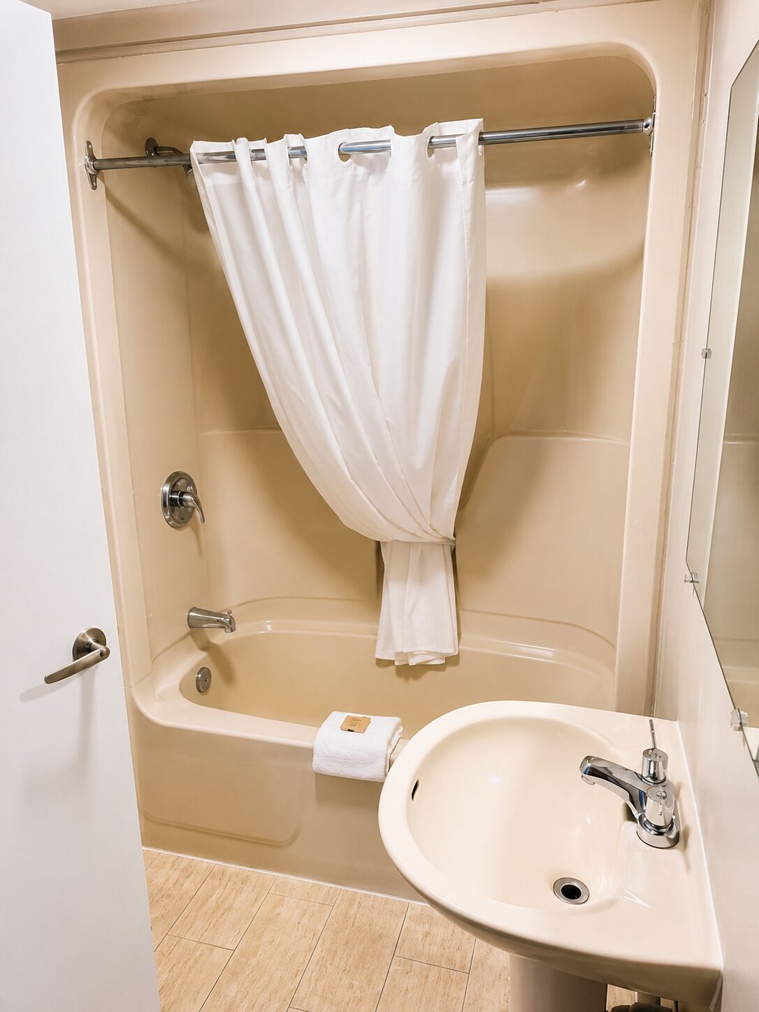Un baño con bañera, lavamanos y cortina de ducha.