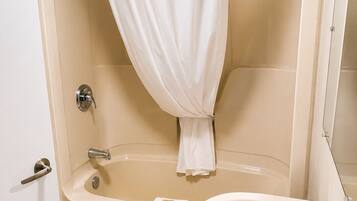Un baño con bañera, lavamanos y cortina de ducha.