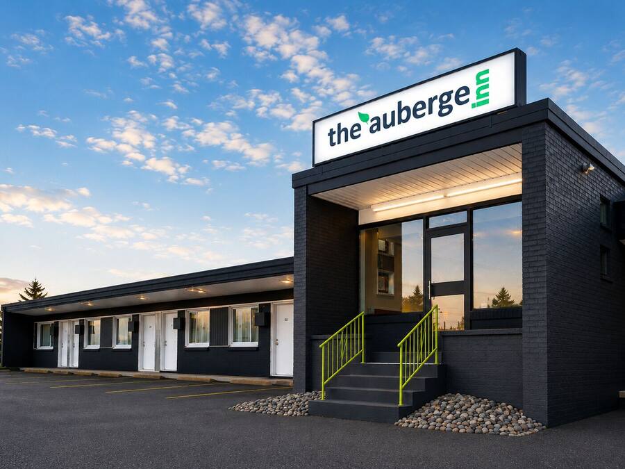 A modern building with a sign reading 'the auberge' and a staircase leading to the entrance.