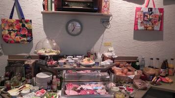 A buffet setup with various food items, a clock, and a radio on the wall.
