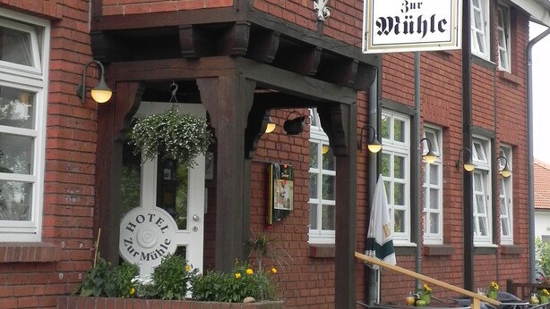 A hotel with a traditional facade, featuring a prominent signboard and a welcoming entrance with steps.