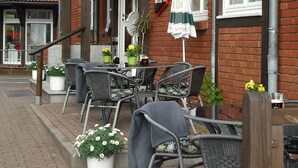 A hotel with outdoor seating, brick walls, and a sign indicating it is a hotel.