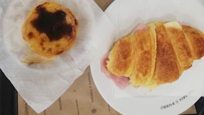 A tray with a glass of orange juice, a cup of coffee, a pastry, and a croissant. - TripGeo Guesthouse (Lisbon)
