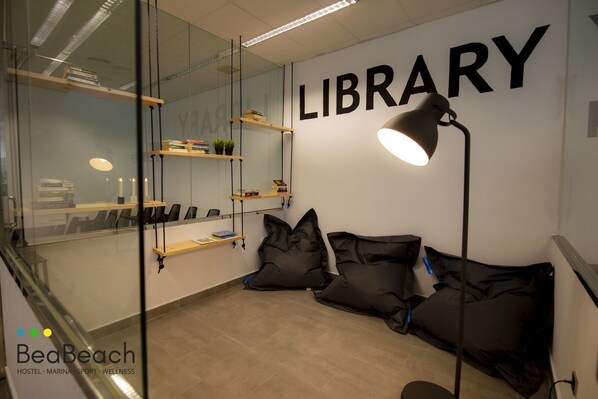 A library area with bookshelves, a desk, and a couch.