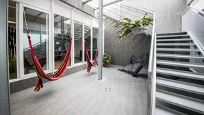 Ein modernes Interieur mit einer Treppe, zwei Hängematten und einem Blumentopf.