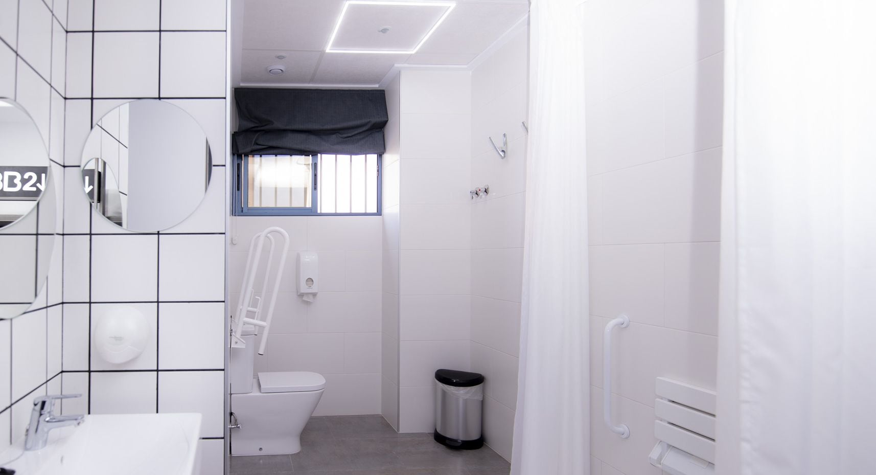 Een moderne badkamer met toilet, bidet en handdroger.