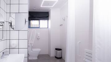 Een moderne badkamer met toilet, bidet en handdroger.